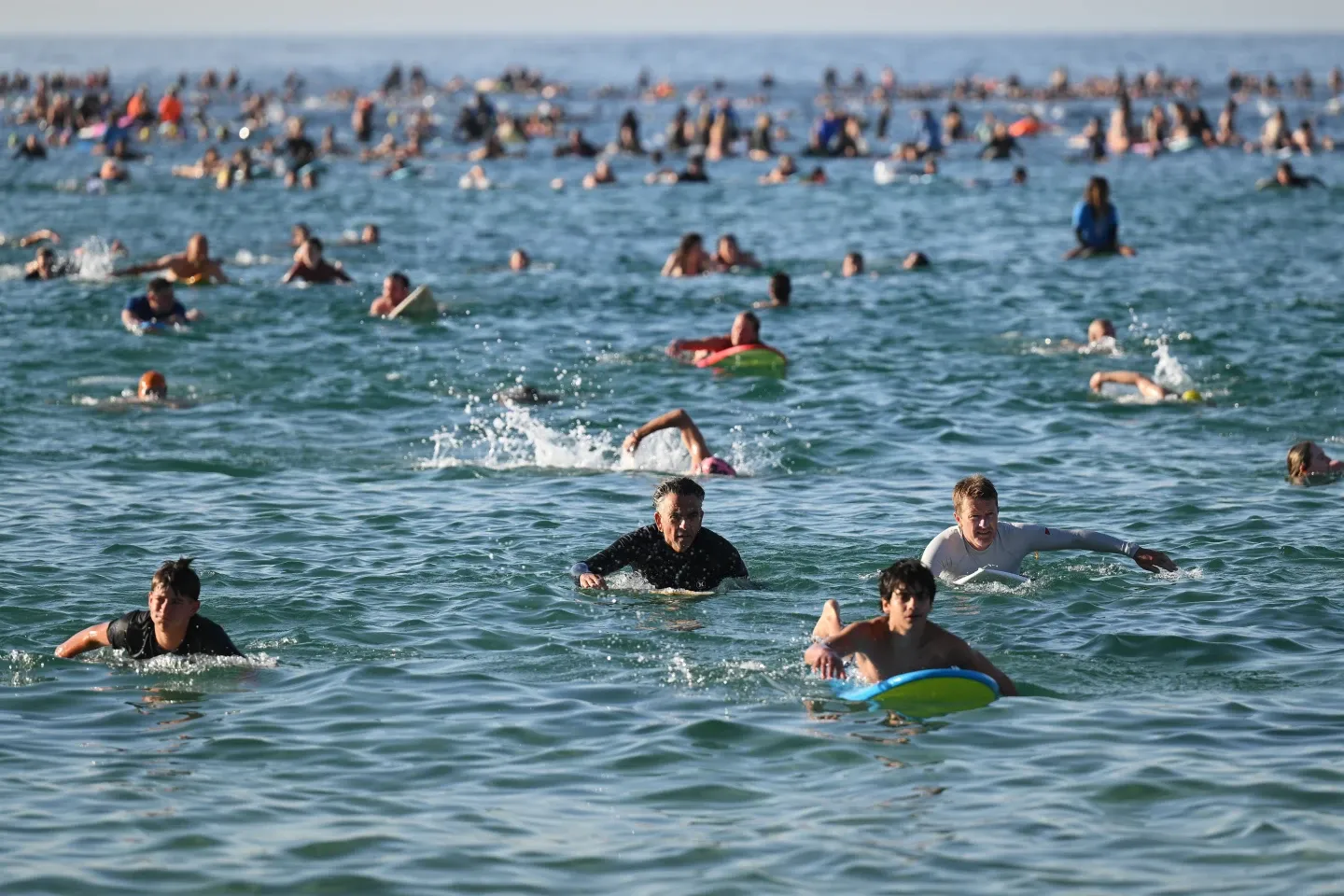 A sunrise crowd gathers at Bondi Beach in solace and defiance after a massacre